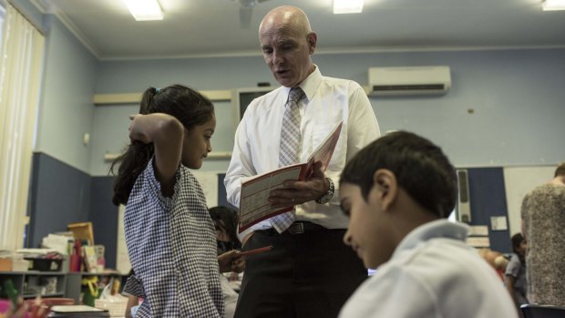 Westmead principal Adrian Mort helps year 2 students with their spelling.