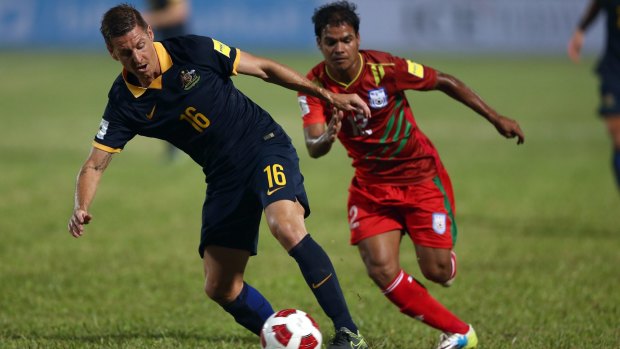 Nathan Burns of the Socceroos evades a challenge from Rayhan Hasan of Bangladesh.