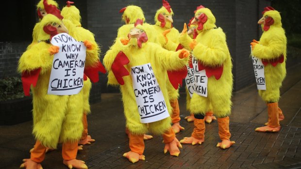 Protesters await Prime Minister David Cameron as he addresses delegates at the Conservative Party's spring forum.