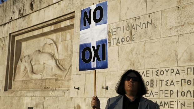 A protester holds a banner in Greek colours in front of the parliament building during an anti-austerity rally in Athens, Greece on Monday.