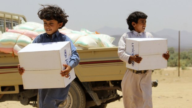Displaced Yemeni children, who fled with their family from the city of Sirwah due to the fighting between Houthi rebels and militiamen loyal to Yemen's fugitive President Abderabbo Mansour Hadi, carry boxes of humanitarian aid donated by UNICEF on Monday.