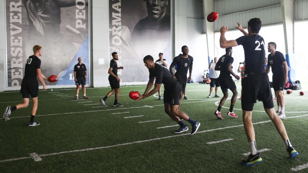 American college basketball players work on their AFL skills during a scouting combine in Florida.