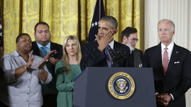 President Barack Obama, joined by Vice President Joe Biden and gun violence victims, wipes a tear from his cheek as speaks in the White House about steps his administration is taking to reduce gun violence.