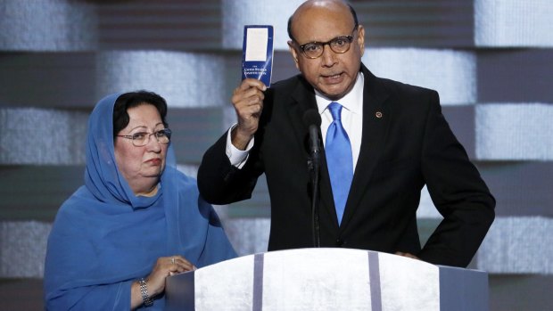 Khizr Khan, father of fallen US Army Captain Humayun S. M. Khan holds up a copy of the Constitution of the United States as his wife listens during the Democratic National Convention in Philadelphia. 