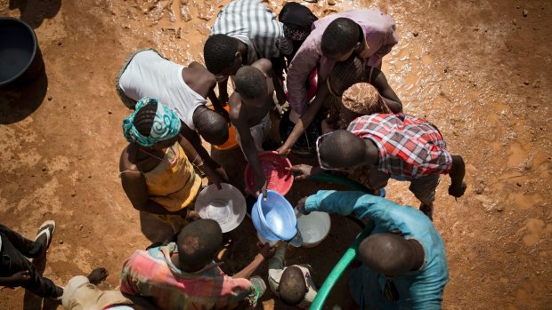 Migrants collect water after they were forcibly expelled from Algeria and returned to Agadez, Niger, via a long drive across the desert last year.