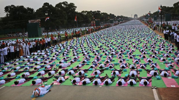 Indian Prime Minister Narendra Modi, left front, lies down on a mat as he performs yoga along with thousands of Indians on Rajpath in Delhi on June 21, the first International Yoga Day.