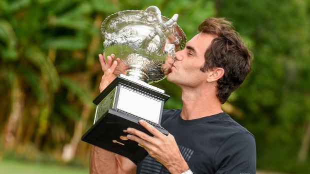 Federer celebrates with the trophy.
