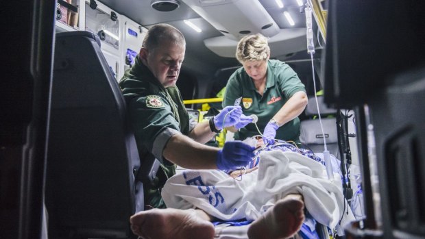 Intensive care paramedics treat a 79-year-old ACT man in the back of an ambulance.