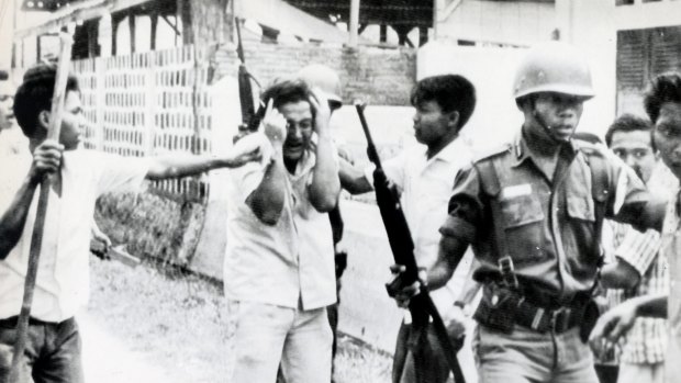 A Chinese student (centre) is pummelled by Indonesian youths who stormed the dormitory of a Communist Chinese University in Jakarta on October 14, 1965.