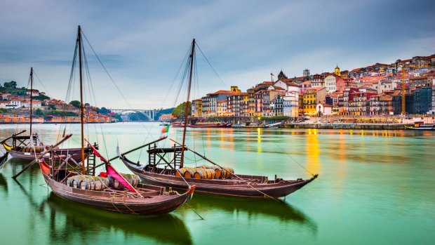 Porto, Portugal old town cityscape on the Douro River with traditional Rabelo boats. 