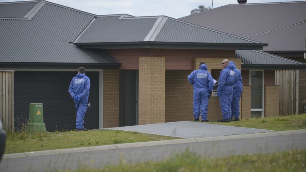 Forensic officers examine a home after the 12-year-old girl was found dead.