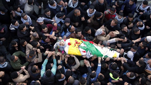 Palestinians carry the body of Ali Taqatqah, 19, on Sunday. The 19-year-old attacked Israeli soldiers with a knife and was shot dead by them. 