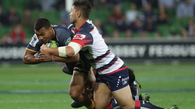 Aidan Toua of the Brumbies is challenged by Colby Faing'a of the Rebels.