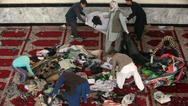 Afghan men collect  belongings inside a damaged mosque in Kabul on Saturday.