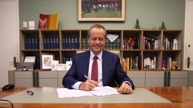 Opposition Leader Bill Shorten poses for photos in his office before delivering his budget reply speech.