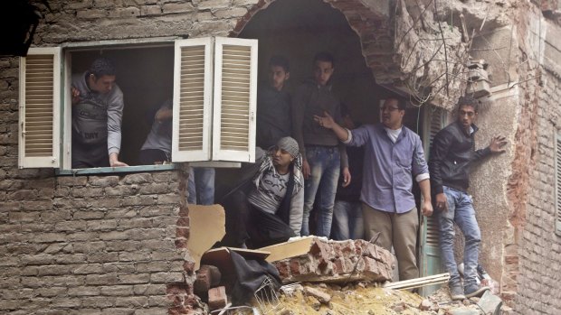 Neighbours watch the rescue operation from their damaged balcony.