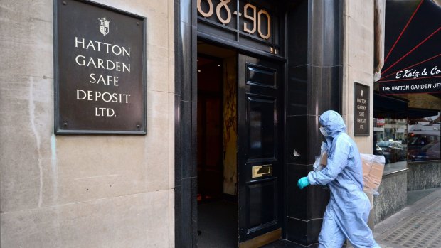 A police forensics officer enters the Hatton Garden Safe Deposit company in London on Tuesday after it was burgled over the weekend.