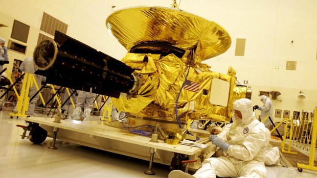 Technicians work on the payload for the New Horizons mission to Pluto on Friday, November 4, 2005, at the Kennedy Space Centre at Cape Canaveral.