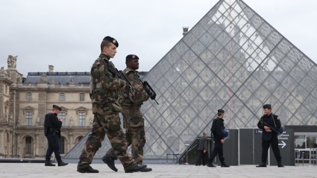 French military patrol the Louvre in Paris, which reopened on Monday.