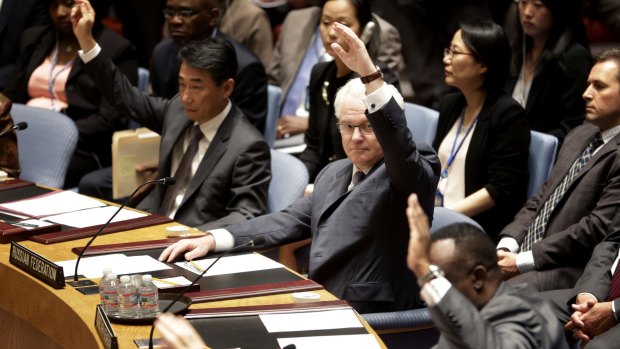 Russian Ambassador to the United Nations Vitaly Churkin, centre, votes in favour of the resolution.