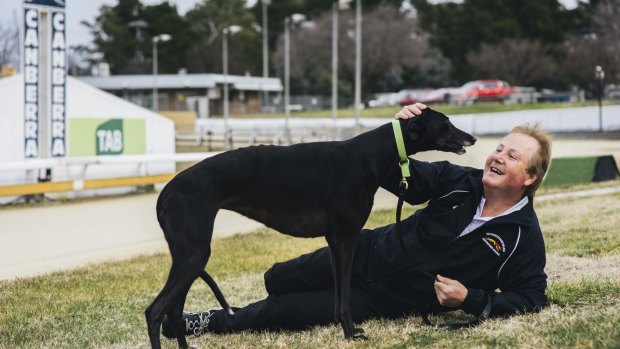 Canberra breeder Alan Tutt with one of his retired greyhounds, La Pearl, who now lives on his couch.