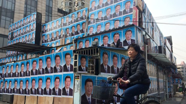 A building covered in portraits of Xi Jinping in Shanghai.