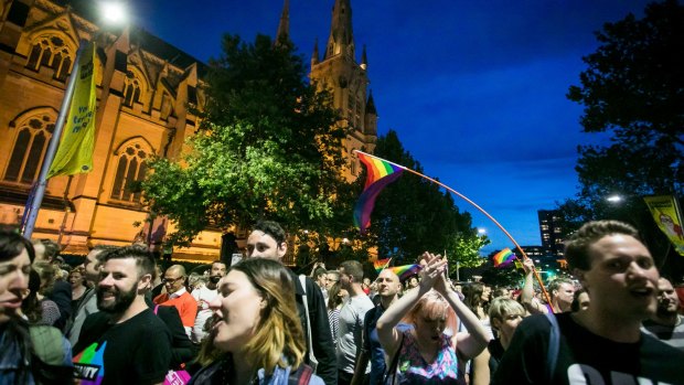 Marriage equality advocates celebrating the ''yes'' vote mark past St Mary's Cathedral in Sydney on Wednesday. 