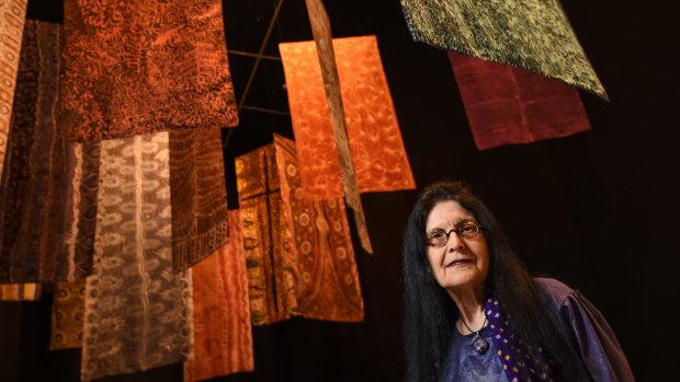 Senior curator of Indigenous art Judith Ryan with batik banners by artists including Emily Kame Kngwarreye in <i>Who's Afraid of Colour?</i> at the at the National Gallery of Victoria. 