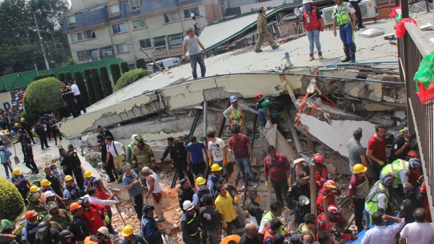 Rescue workers search for children trapped inside the collapsed Enrique Rebsamen school in Mexico City.