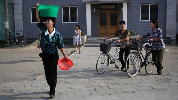 North Korean women make their way across a road in North Korea's second-largest city, Hamhung, on Thursday.