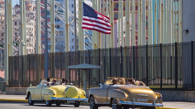 Tourists ride vintage American convertibles as they pass by the United States embassy in Havana, Cuba, as tensions eased last year.