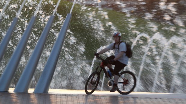 A cyclist adds a water hazard to his ride at Sydney Olympic Park.