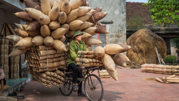 Wicker sellers cart their goods around Hanoi on bicycles.