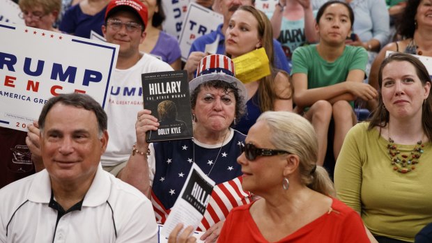 A Trump supporter holds a copy of Dolly Kyle's recently published expose on Hillary Clinton at a campaign rally in New Hampshire.