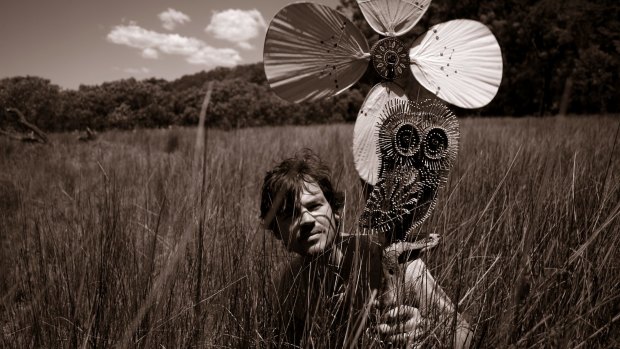 Joshua Yeldham near Sydney's Hawkesbury River with a wooden owl that he carved in 2008.
