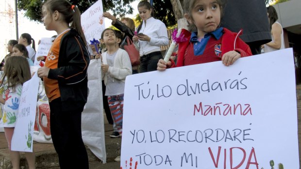 A young girl holds a sign reading in Spanish "You'll forget it, me, I will remember it for the rest of my life," at a demonstration in front of the Attorney General's office in Ciudad del Este, Paraguay in May. 