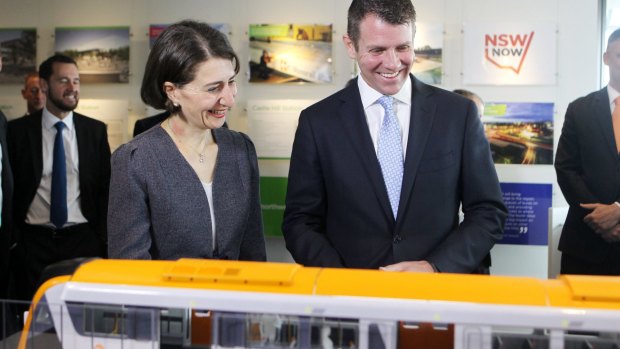 All aboard: Mike Baird and Gladys Berejiklian study a model of the new rolling stock at this week's announcement. 