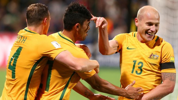 Socceroo Massimo Luongo is congratulated by Brad Smith and Aaron Mooy after scoring one of Australia's two goals against Iraq in Perth.