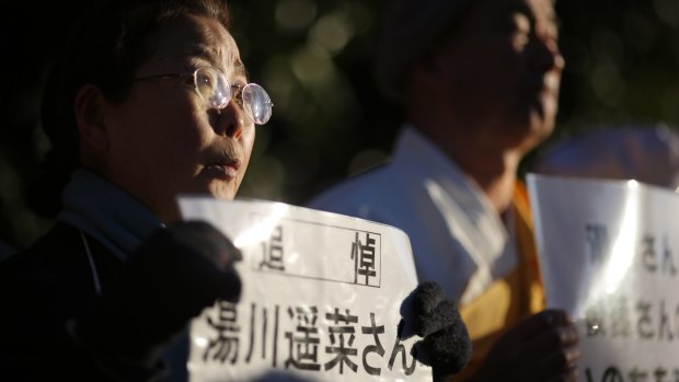 A woman, holding a sign stating: "In memory of Mr Haruna Yukawa," takes part in a vigil outside the Japanese prime minister's residence in Tokyo on Sunday.