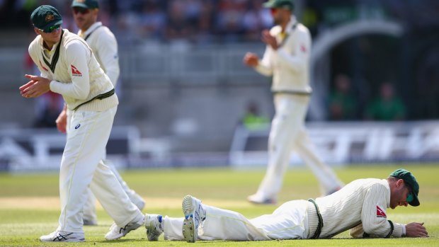 Tough match: Michael Clarke lies grounded after spilling a catch from Ian Bell at second slip.