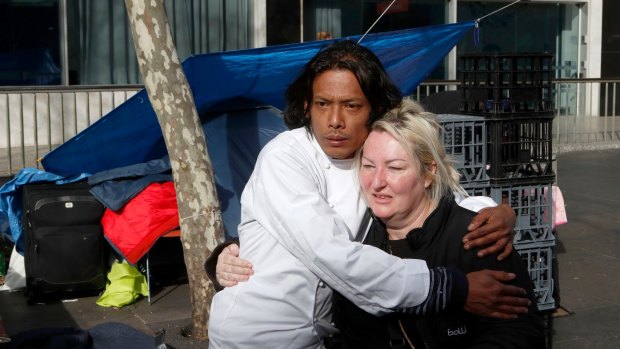 Residents of the Martin Place tent city embrace before packing up.