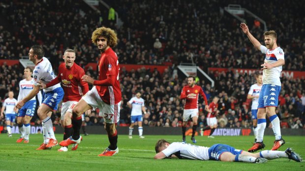 Manchester United's Marouane Fellaini (left) celebrates after scoring against Wigan in the FA Cup fourth-round clash.