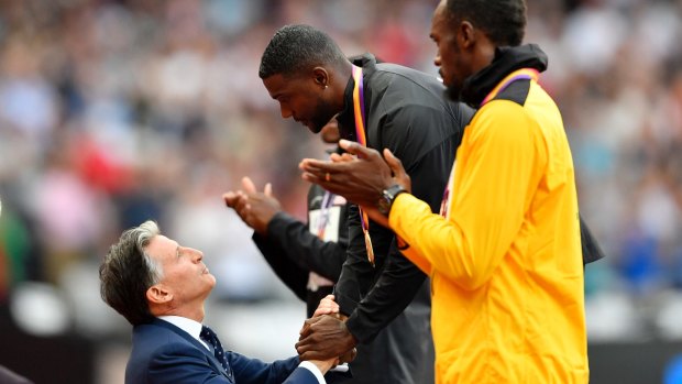 Justin Gatlin receives his gold medal from IAAF boss Sebastian Coe as Usain Bolt looks on from the bronze medal position.