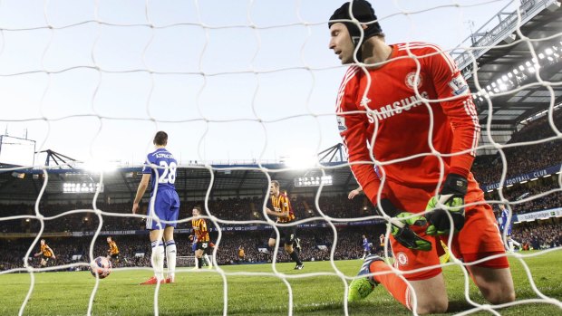 It's behind you: Petr Cech looks on as Bradford City celebrate a giant killing.