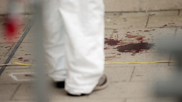 Forensic specialists examine blood at the crime scene.