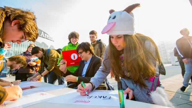 Fans make signs ahead of the 2015 world championship finals.