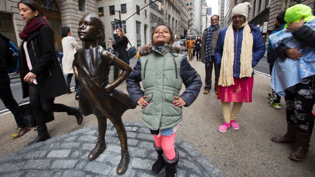 Strike a pose: Shriya Gupta, a girl from Cherokee, North Carolina, is having her picture taken with the "Fearless Girl".
