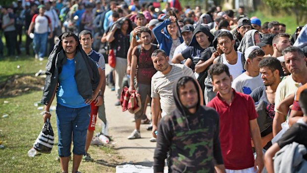 Refugees wait to board buses at Tovarnik railway station following their crossing from Serbia on Friday.