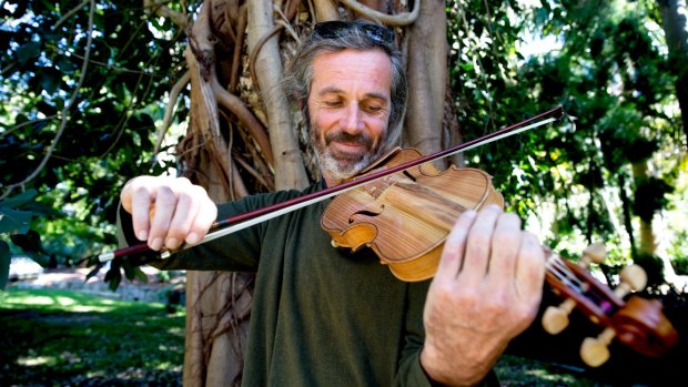Can you play some Bach? Mikey Floyd demonstrates his exquisite violin made from the garden's 'waste' timber.