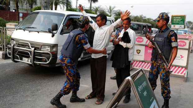 An airport security personnel frisks a passenger as other stands guard outside the airport terminal in Dhaka, Bangladesh, on Friday, March 17, 2017.